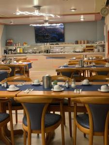 een klaslokaal met tafels en stoelen en een keuken bij Hotel an der Hörn in Kiel