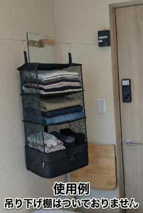 a room with a rack with folded clothes on it at Sho inn MINIMAL HOTEL 小樽駅から無料送迎あり in Otaru