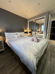 een slaapkamer met een groot bed en een grote spiegel bij KM Granton Apartment in Edinburgh