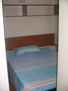 Un dormitorio con una cama con cabecero de madera. en Camping Helios Triscina, en Triscina