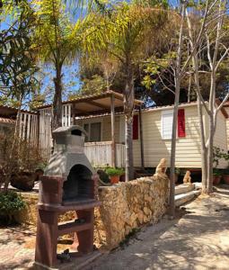 un horno de piedra frente a una casa en Camping Helios Triscina, en Triscina