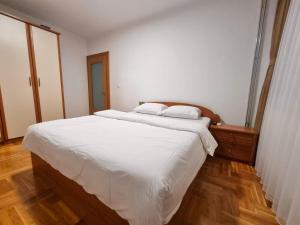 ペヤにあるEden Hostel Pejaの白いシーツが敷かれた大きなベッドのある寝室