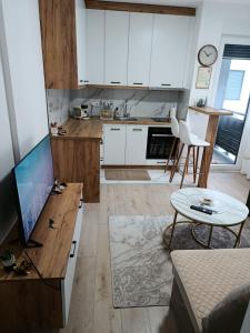ブルチコにある"INKOGNITO Centar" Apartmanの白いキャビネットとテーブル付きのキッチン