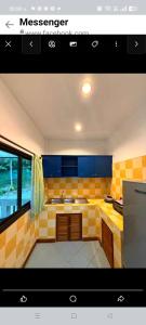 una cocina con azulejos amarillos y azules en la pared en Baan WangNaKha, en Koh Samui