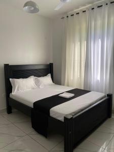 a bedroom with a large bed with white curtains at High Tide BnB Apartment in Mombasa