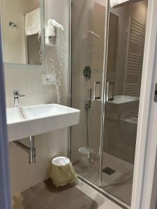 Un baño blanco con ducha y lavabo. en NINFEA sweethome, en Foggia 7 fotos más