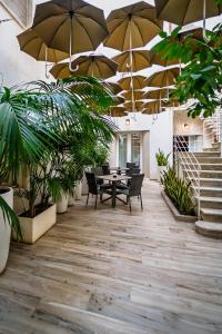a patio with a table and chairs and umbrellas at Il cortile di Elen in Marsala