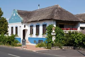 a blue and white house with a thatched roof at Bio Archehof - Zur Grube in Podersdorf am See