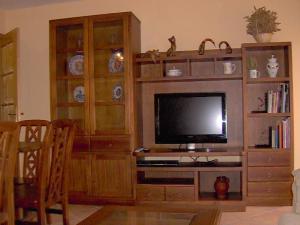a living room with a television in a wooden entertainment center at Villa de La Yunta in La Yunta