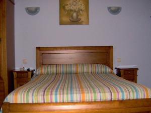 a bed with a striped comforter in a bedroom at Villa de La Yunta in La Yunta