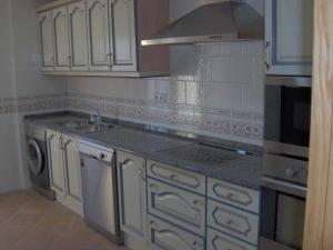 a kitchen with white cabinets and a stove top oven at Villa de La Yunta in La Yunta