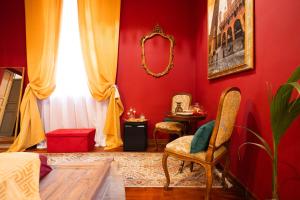 a bedroom with red walls and a mirror and a chair at Villa Meraville B&B in Bologna +54 photos
