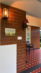 eine Backsteinmauer mit einer Bank neben einem Gebäude in der Unterkunft The Green Thumb Farm Stay in Mundakāyam