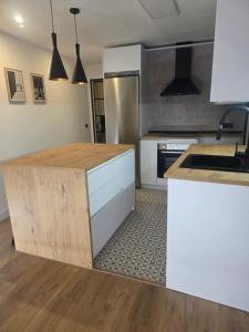 a kitchen with white cabinets and a wooden counter top at Sweet Dreams Olivares in Talavera de la Reina