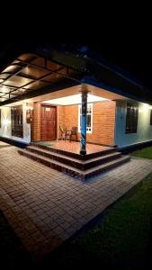 a small house with a patio at night at The Green Thumb Farm Stay in Mundakāyam