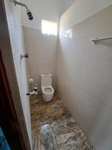 a bathroom with a toilet in a stall at Palm Breeze Kokuvil in Jaffna