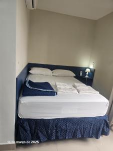 a large white bed with a blue headboard in a room at Studio | Expo Stay Tucuruvi Metro |Swimming pool in São Paulo