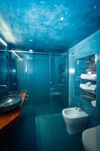 a blue bathroom with a sink and a toilet at Il cortile di Elen in Marsala +66 photos