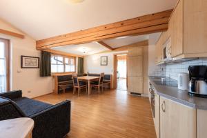 eine Küche und ein Wohnzimmer mit Tisch und Stühlen in der Unterkunft Gästehaus Hartweger in Haus im Ennstal