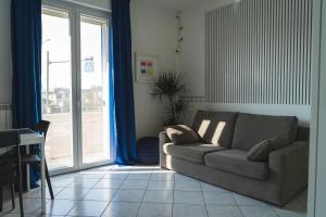 ein Wohnzimmer mit einer Couch neben einer Glasschiebetür in der Unterkunft WowMilano Escape in Melegnanello