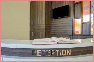 Un mostrador de recepción con dos libros encima. en Chakra Tirtha Road Moon Rise Residency Near Jagannath Temple And Fully Air conditione-# Free Wifi And Room Service #Budget Class Best Hotel IN Puri, en Puri