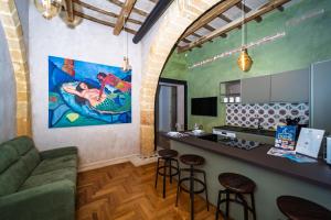 a living room with a green couch and a bar at Il cortile di Elen in Marsala