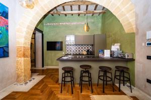 a kitchen with a counter and stools in a room at Il cortile di Elen in Marsala