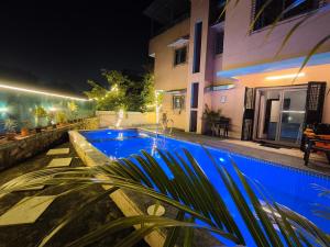 a swimming pool in front of a house at night at Golden Maple Villa in Jāmb