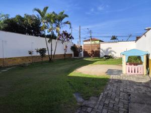 圣塞巴斯蒂安Sobrado em São Sebastião的院子里有个凉亭，旁边是一堵白墙。