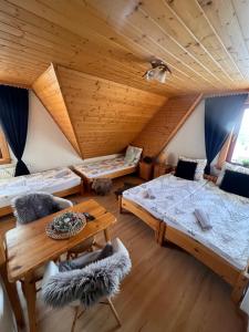 a room with three beds and a wooden ceiling at Czekoladowa Willa in Białka Tatrzanska