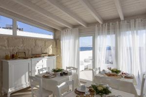 ein Esszimmer mit weißen Tischen und weißen Stühlen in der Unterkunft Petra Bianca in Torre San Giovanni Ugento