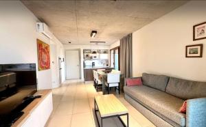 a living room with a couch and a table at Btwins Pinamar in Pinamar