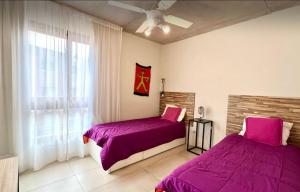 a bedroom with two beds and a window at Btwins Pinamar in Pinamar +10 photos
