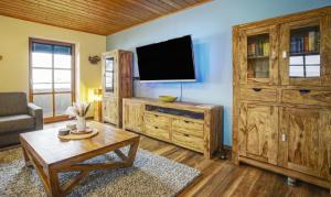 ein Wohnzimmer mit einem Flachbildfernseher an der Wand in der Unterkunft Ferienwohnung Freudensee im Bayerischen Wald - Pool, Sauna in Hauzenberg