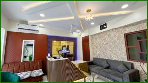 una sala de estar con un sofá y una mesa en Near Mahakal Temple G- Residency Near Railway Station - Air Conditioned hotel at Prime Location - Lift and Parking - BEST HOTEL IN UJJAIN, en Ujjain