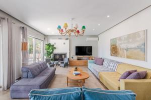 un soggiorno con due divani e una TV di Rivazzurra Beachfront Luxury Villa a Lithakia