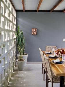 a dining room with a table and a plant at Villa Egeu Praia da Pipa in Pipa