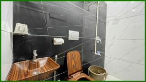y baño con lavabo de madera y aseo. en Near Mahakal Temple G- Residency Near Railway Station - Air Conditioned hotel at Prime Location - Lift and Parking - BEST HOTEL IN UJJAIN, en Ujjain