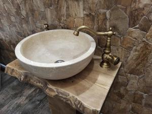 a sink in a stone bathroom with a tap at Cerdacul cu Amintiri in Câmpulung Moldovenesc +56 photos