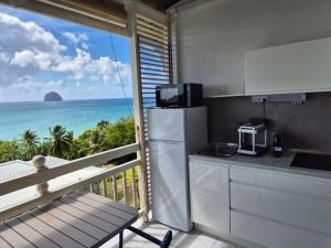 a kitchen with a balcony with a view of the ocean at On Ze Rock in Le Diamant