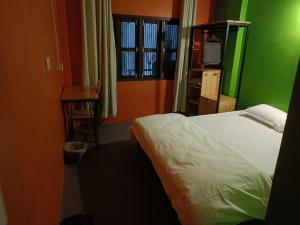 a bedroom with a bed and a table and a window at Hotel Baishnav in Upardāng Garhi +2 photos