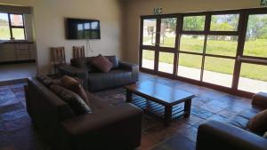 a living room with couches and a coffee table at Mthontsi Lodge in Kroomie