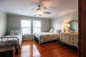 Un dormitorio con dos camas y un ventilador de techo. en Commander, en Edisto