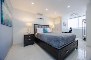 a bedroom with a bed with a nightstand and a window at Beachfront Oceanview Condo 1 Bedroom Balcony and Pool in San Juan +22 photos