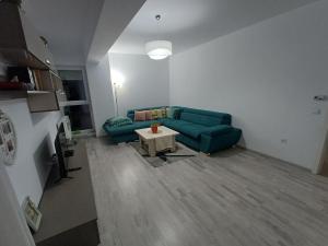 a living room with a green couch and a table at Favorite Apartmet in Braşov