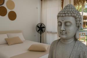 posąg w sypialni obok łóżka w obiekcie Bali Lodge Máncora - Playa, Piscina & Desayuno w mieście Máncora +14 zdjęć