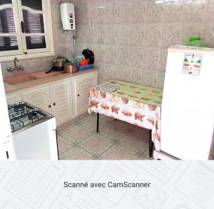 a kitchen with a refrigerator and a table in it at Studio AMINE in Mahdia +2 photos