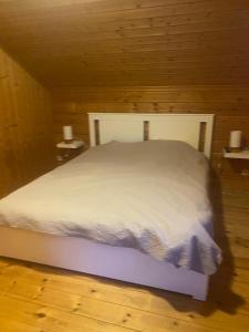 a bedroom with a white bed in a wooden room at Le Havre de Bois in Bourbourg +13 photos