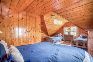 a bedroom in a log cabin with a large bed at Cannons Cottage in Cannon Beach