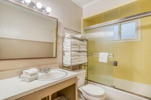 a bathroom with a sink and a toilet and a mirror at Cannons Cottage in Cannon Beach +34 photos